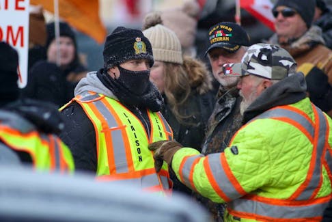  Hundreds of people assembled at the Manitoba Legislative Building to demonstrate against the so called “Freedom Convoy” on Saturday. Feb. 12. 2022. Police were on scene, there appeared to be no serious incidents. In this photo an anti mandate protester speaks to a police officer. 