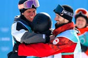  BEIJING, CHINA – FEBRUARY 15: Gold Medallist Yiming Su of Team China (C), Silver medallist Mons Roisland of Team Norway (L) and Bronze medallist Max Parrot of Team Canada (R) embrace during the Men’s Snowboard Big Air final on Day 11 of the Beijing Winter Olympics at Big Air Shougang on February 15, 2022 in Beijing, China.