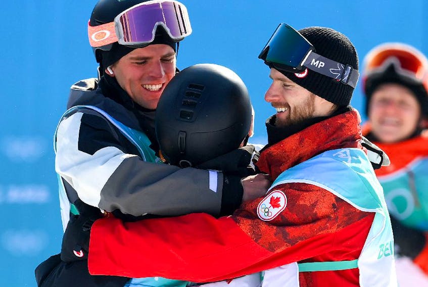  BEIJING, CHINA – FEBRUARY 15: Gold Medallist Yiming Su of Team China (C), Silver medallist Mons Roisland of Team Norway (L) and Bronze medallist Max Parrot of Team Canada (R) embrace during the Men’s Snowboard Big Air final on Day 11 of the Beijing Winter Olympics at Big Air Shougang on February 15, 2022 in Beijing, China.