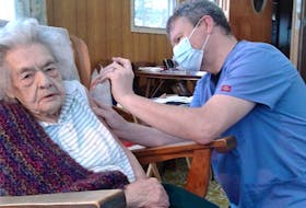 Pharmacist Graham MacKenzie, right, gives Margaret MacPhee her COVID-19 booster vaccination inside her Baddeck home in January. MacPhee turned 107 on Feb. 9. CONTRIBUTED