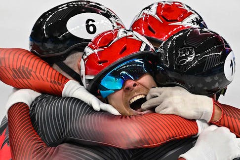 Canada team members celebrate after winning the final A of the men's 5000m relay short track speed skating event during the Beijing 2022 Winter Olympic Games. 