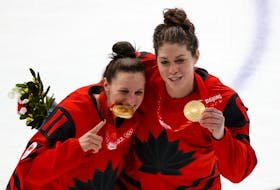 Canadian players  Jillian Saulnier of Halifax and Rebecca Johnston  of Sudbury, Ont.,   pose with their gold  medals after winning the championship game at the Beijing Olympics on Thursday. Johnston, who has family in Dartmouth, captured her third gold medal. REUTERS/David W Cerny