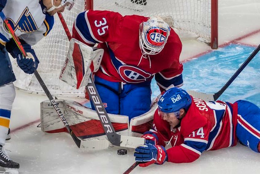 Montreal Canadiens defenseman Corey Schueneman (64) helps Canadiens goaltender Sam Montembeault (35) cover up the puck with St. Louis Blues left wing Pavel Buchnevich (89) looking on during second period in Montreal on Thursday, Feb. 17, 2022.