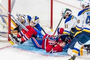 Montreal Canadiens right wing Brendan Gallagher (11) collides with St. Louis Blues goaltender Ville Husso (35) while being checked by defenseman Robert Bortuzzo (41) during first period against the St. Louis Blues in Montreal on Thursday, Feb. 17, 2022. 