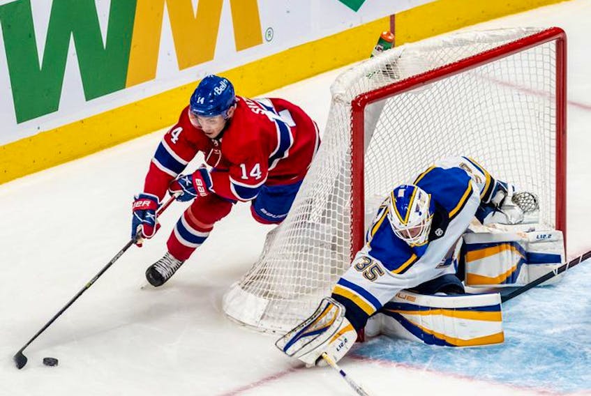 Montreal Canadiens centre Nick Suzuki (14) tries a wrap-around against St. Louis Blues goaltender Ville Husso (35) during first period against the St. Louis Blues in Montreal on Thursday, Feb. 17, 2022. 