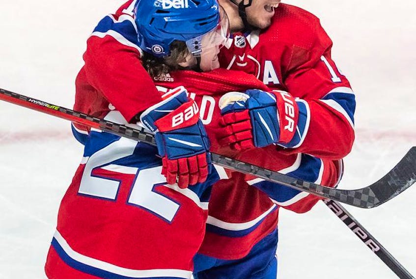 Montreal Canadiens right wing Cole Caufield (22) is congratulated by teammate Montreal Canadiens centre Nick Suzuki (14) after scoring the tying goal against the St. Louis Blues in the dying seconds of the third period in Montreal on Thursday, Feb. 17, 2022.
