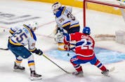 St. Louis Blues centre Jordan Kyrou (25) couldn't prevent Montreal Canadiens right wing Cole Caufield (22) from scoring the game winning overtime goal against St. Louis Blues goaltender Ville Husso (35) in Montreal on Thursday, Feb. 17, 2022. 