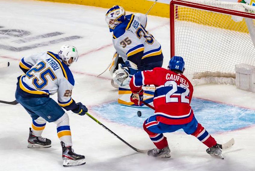 St. Louis Blues centre Jordan Kyrou (25) couldn't prevent Montreal Canadiens right wing Cole Caufield (22) from scoring the game winning overtime goal against St. Louis Blues goaltender Ville Husso (35) in Montreal on Thursday, Feb. 17, 2022. 