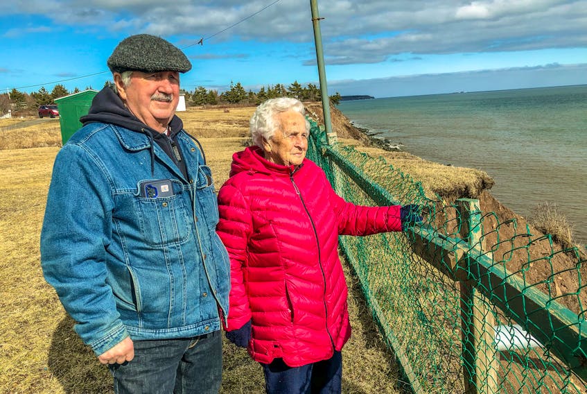 Stan Peach, left, stands with his mother Joyce Peach, right, at the end of her backyard at her house in Port Morien, looking out over the eroding cliffside. JESSICA SMITH/CAPE BRETON POST