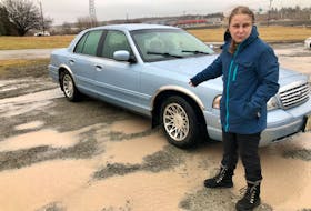 Meghan Ivany, 26, points to the tire that was ruined after hitting a pothole on Welton Street on Feb. 15. NICOLE SULLIVAN/CAPE BRETON POST 
