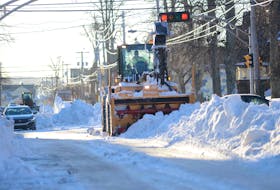 A piece of snow clearing equipment waits on Prince Street in Charlottetown on Feb. 1. After a weekend storm, crews piled snow into the middle of some streets where machinery blew it into dump trucks to be hauled away. Crews were still busy clearing streets several days after the snowfall. Another storm is forecast to hit the province overnight on Feb. 3.