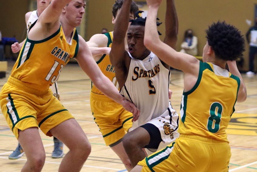 Dartmouth High's Kyree Thompson tries to split two Halifax Grammar School defenders during last season's metro high school boys' basketball league championship game. - Eric Wynne
