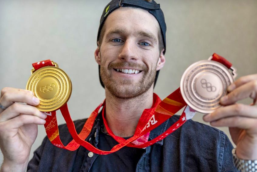 Canadian Olympic snowboarder Max Parrot shows off the gold and bronze medals he won at the Winter Games in Beijing during a news conference in Montreal on Tuesday, February 22, 2022. 