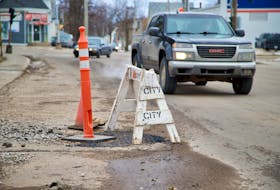 Drivers make their way around a pothole next to a manhole cover on Euston Street in front of the Community Outreach Centre. On Feb. 22, the City of Charlottetown put out a release saying it is going to begin repairing various potholes across the city.