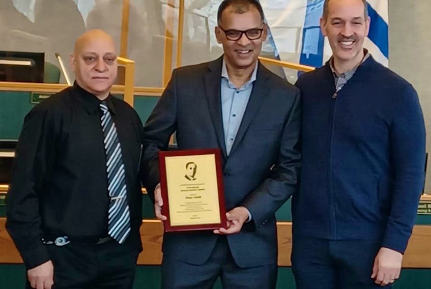 Dean Smith, centre, holds the Tom Miller Human Rights Award of 2022, which was received during a ceremony Monday morning at city hall in Sydney. With him are Cape Breton Regional Municipality councillor Lorne Green, left, and Wayne Miller. CONTRIBUTED