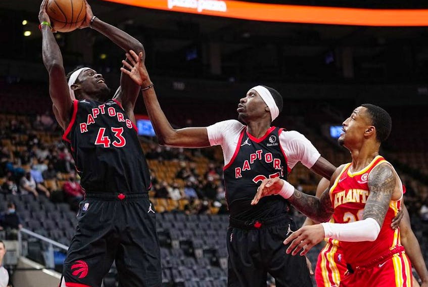Toronto Raptors forward Pascal Siakam comes down with a rebound as forward Chris Boucher and Atlanta Hawks forward Kevin Knox II look on during the first half at Scotiabank Arena. 