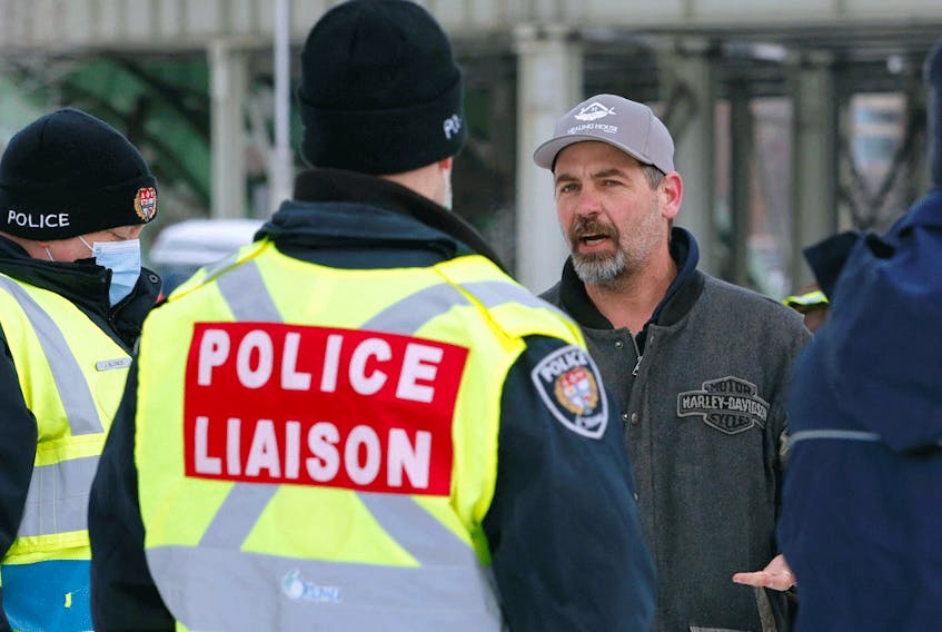 Truckers and supporters talk with police liaison officers as they continue to protest COVID-19 mandates, February 4, 2022. Late this week, the convoy organizers welcomed a disgruntled RCMP corporal to their ranks.