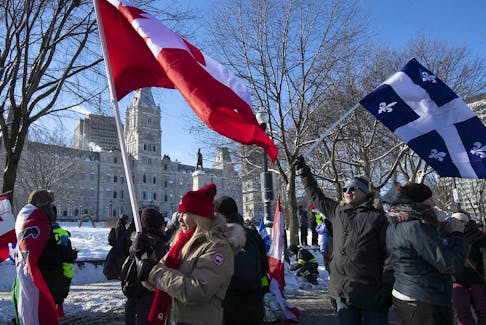 Protesters walk next to Quebec's National Assembly during a protest against COVID-19 vaccines and health restrictions on Feb. 5, 2022.