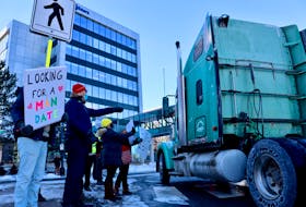 Counter-protesters line the sidewalks near Lower Water Street in Halifax as the anti-mandate truck convoy drives through on Sunday, Feb. 6, 2022.