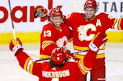  The Calgary Flames’ Johnny Gaudreau (left) celebrates with Sean Monahan and Rasmus Andersson after scoring a goal against the Florida Panthers at Scotiabank Saddledome in Calgary on Jan. 18, 2022.