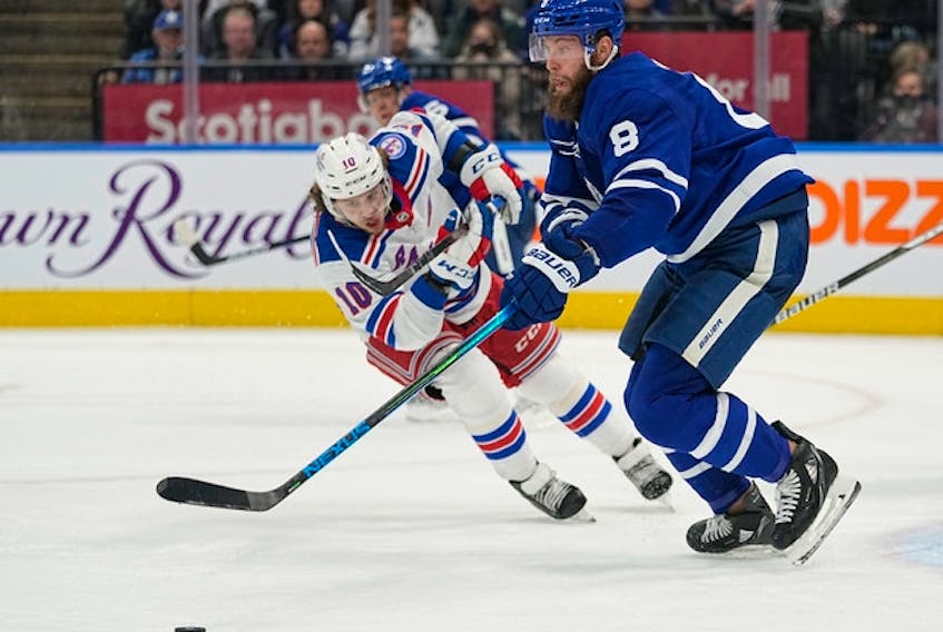 Maple Leafs defenceman Jake Muzzin goes after a loose puck against the New York Rangers. No date has been set for Muzzin's return from a concussion, though he did participate in contacts drills on Sunday.