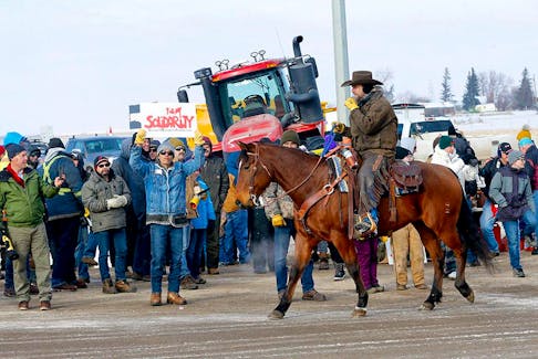 Authorities deal with a new road block on Highway 4 and 501 outside of Milk River heading towards the Coutts border crossing but protesters where letting trucks through on one lane on Thursday, February 3, 2022. 