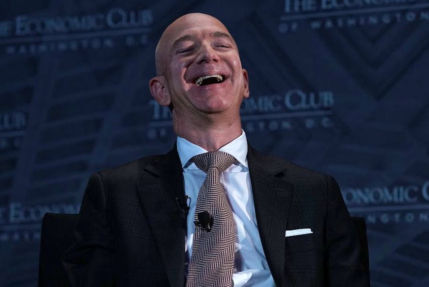 Jeff Bezos laughs as he participates in a discussion during a Milestone Celebration dinner Sept. 13, 2018 in Washington, D.C.