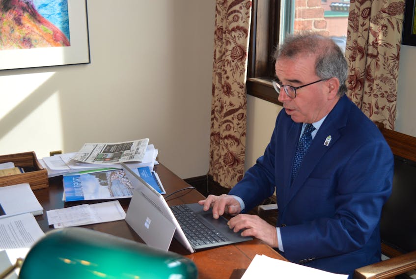 Charlottetown Mayor Philip Brown works at his desk at city hall on March 1, going over some of the resolutions passed during a special meeting of council the night before.