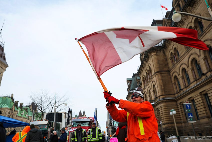 A protester taking part in the anti-mandate demonstration waves a Canadian flag in downtown Ottawa. 