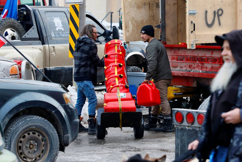 Protestors unload gas cans from the back of a truck in Ottawa on Feb. 8, 2022 as part of a demonstration against COVID-19 mandates. 