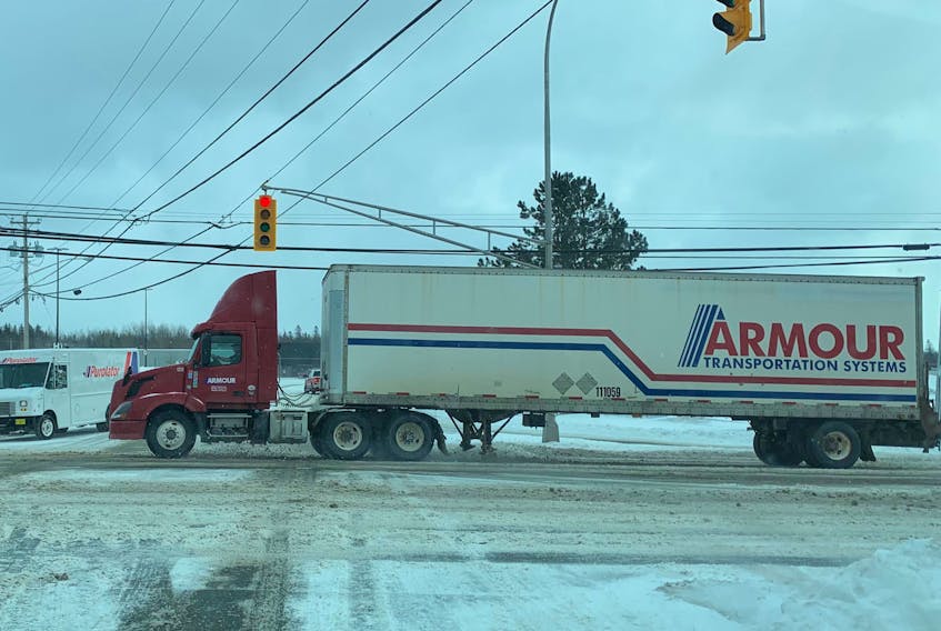 At any given time, trucks of all sizes are plying the roads of Cape Breton picking up and dropping off every item imaginable. Above, a large truck and trailer pass by a waiting delivery van at the intersection of Grand Lake Road and the Mayflower Mall. DAVID JALA/CAPE BRETON POST