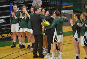 UPEI Panthers head coach congratulates Matt Gamblin and senior Jenna Mae Ellsworth during a ceremony honouring the team’s three graduating players on March 5. Ellsworth, whose season ended after a knee injury in November, is the all-time points leader in the history of the UPEI women’s basketball program.