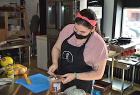 Julie Hewitt, one of the chefs at Cured Creations in Charlottetown, works with peco in the kitchen on March 11.