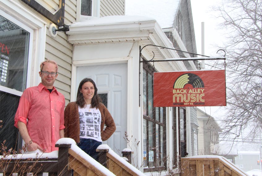 The Roquette Kitchen owners Chris Coupland, left, and Brittany Cole stand in front of Back Alley Music Store in Charlottetown, the location of their new grab-and-go sandwich and soup business.