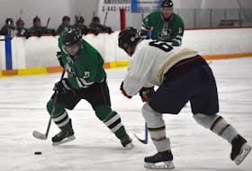 Steve MacNeil of the Glace Bay Crusaders, left, carries the puck as defenceman Darrell Beaton of Ross Printing attempts to poke the puck away during U Division championship action at the Vince Ryan Memorial Scholarship Hockey Tournament at the Dominion and District Community Centre in 2019. The annual tournament will return this year after being cancelled the last two years due to the COVID-19 pandemic. JEREMY FRASER · CAPE BRETON POST