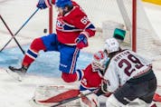 The puck sails past Montreal Canadiens goaltender Sam Montembeault (35) and Montreal Canadiens center Mike Hoffman (68) on a shot from Arizona Coyotes center Barrett Hayton (29) during 1st period NHL action at the Bell Centre in Montreal on Tuesday, March 15, 2022.