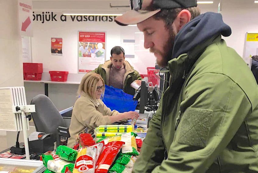 Trevor MacDonald took this photo of friend Robbie Walker as they bought food at a grocery store in Budapest, Hungary, to help feed Ukrainians who are arriving in the city by train each day. “I’ll stay here as long as I’m needed,” MacDonald said. Contributed/Trevor MacDonald