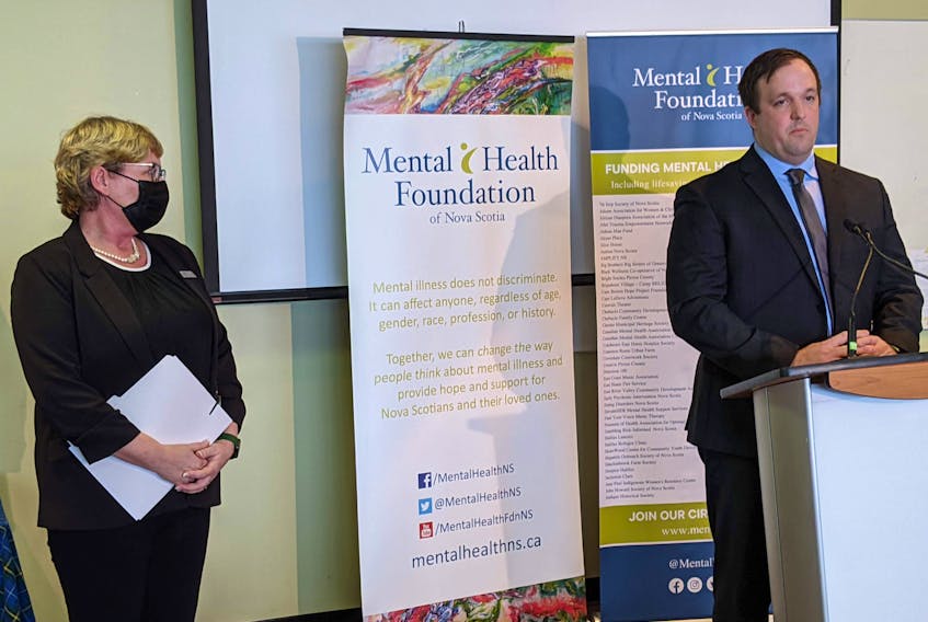 Starr Cunningham, CEO and president of the Nova Scotia Mental Health Foundation listens to Brian Comer, minister of addictions and mental health, at an announcement of $3 million for the foundation.