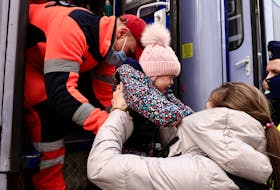 A woman and her child, who fled Russia's invasion of Ukraine, are helped by a medic to board a train run by the Polish Red Cross and reserved for people who need medical care, to be transported to Wroclaw’s hospital after crossing the border from Ukraine to Poland. - REUTERS/Zohra Bensemra