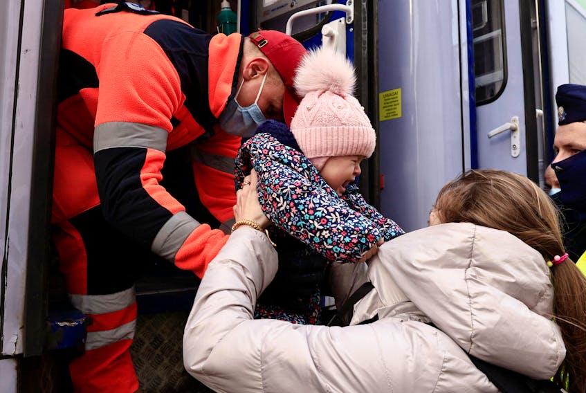 A woman and her child, who fled Russia's invasion of Ukraine, are helped by a medic to board a train run by the Polish Red Cross and reserved for people who need medical care, to be transported to Wroclaw’s hospital after crossing the border from Ukraine to Poland. - REUTERS/Zohra Bensemra