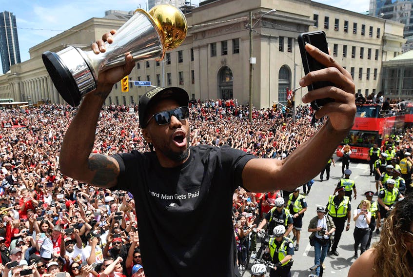  Kawhi Leonard takes a selfie holding his playoffs MVP trophy as he celebrates during the 2019 Toronto Raptors Championship parade in Toronto on June 17, 2019.