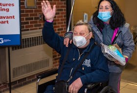 Vadim Bolotin waves to his grandchildren as his daughter, Iryna Maleyeva, wheels him into the arrivals area of the Charlottetown airport.  