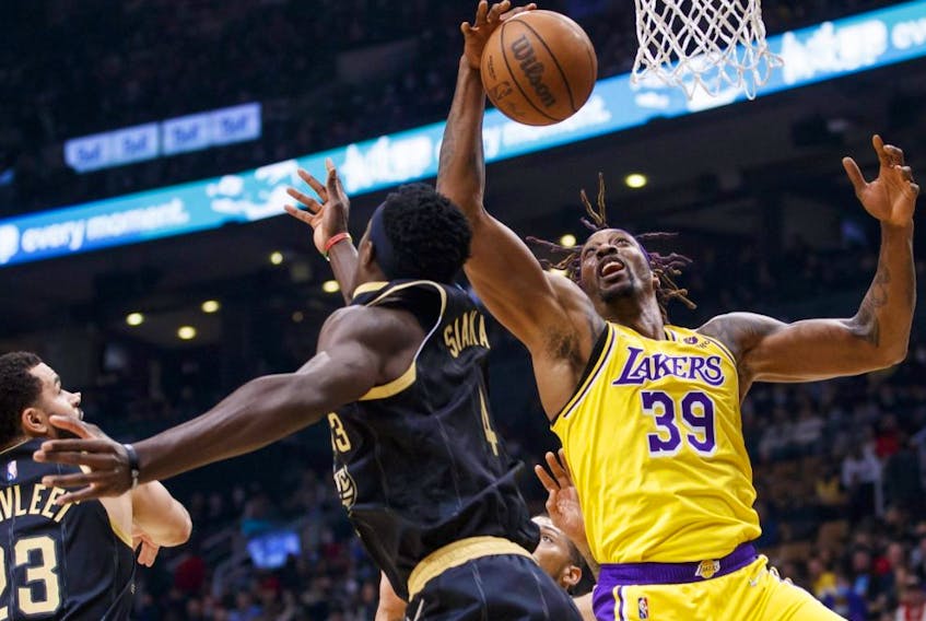 Lakers' Dwight Howard, right, grabs a rebound from Raptors' Pascal Siakam, centre, during first half NBA action at Scotiabank Arena in Toronto, Friday, March 18, 2022.