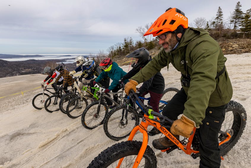 Race organizer Adam Shore, right, and the other participants of the first Mass Start Madness mountain bike race at Ski Cape Smokey on Saturday begin the steep decline to the bottom of the snowy mountain. CONTRIBUTED/DESTINATION CAPE BRETON