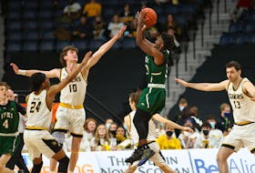 Elijah Miller of the UPEI Panthers focuses on releasing a jump shot over Dalhousie Tigers’ defenders Samuel Maillet, 10, and Shamar Burrows, 24, during the Atlantic University Sport (AUS) men’s basketball championship game in Halifax, N.S., on March 20. The Tigers rallied for an 84-78 victory. 