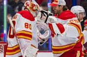  Calgary Flames goaltenders Dan Vladar and Jacob Markstrom celebrate the club’s 5-2 win over the Vancouver Canucks at Rogers Arena in Vancouver on Saturday, March 19, 2022.