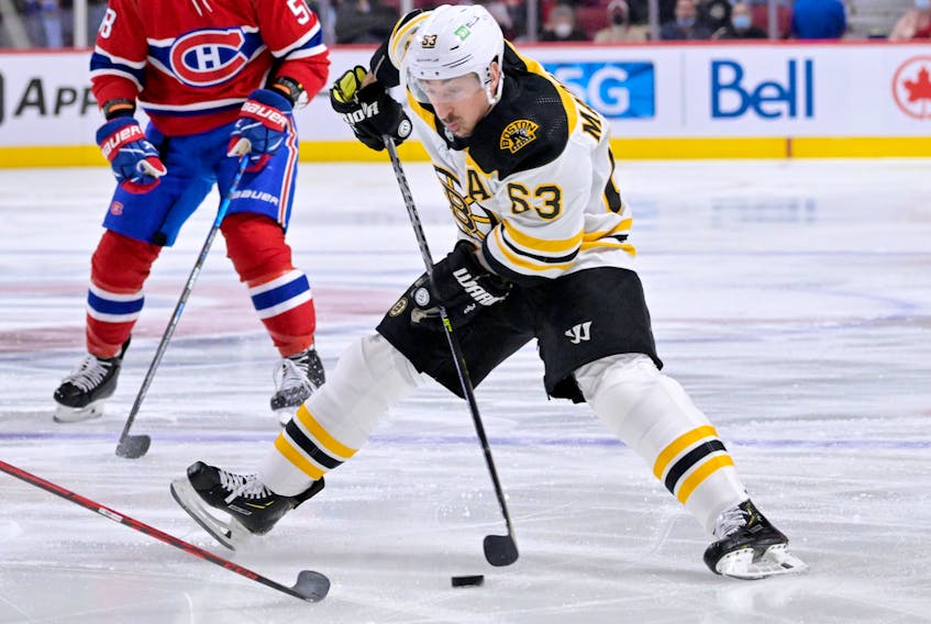 Boston Bruins forward Brad Marchand (63) plays the puck during the first period against the Montreal Canadiens at the Bell Centre in Montreal on Monday, March 21, 2022. - Eric Bolte / USA TODAY Sports