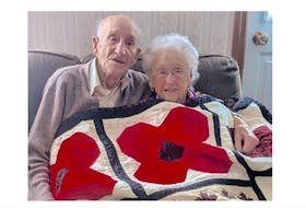Charles (Charlie) Muise and his wife Annie, who this July will celebrate 80 years of marriage, enjoy some snuggle time with the quilt. Both are 100 years old. ANDRE BOUDREAU PHOTO