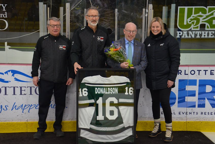 The University of Prince Edward recently acknowledged the contributions of Bruce Donaldson, second right, to the women’s hockey program. During the ceremony at MacLauchlan Arena, Donnie MacFadyen, left, team manager and the founder of the UPEI women's hockey program, UPEI varsity co-ordinator Ron Annear and UPEI director of athletics and recreation Jane Vessey presented Donaldson with a framed Panthers jersey. Donaldson is stepping down as head coach at the end of this week’s U SPORTS women’s hockey championship at UPEI.