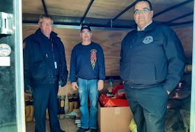 Lyle Donovan, centre, emergency management coordinator for Victoria County is working with the Canadian Bomberos to collect much-needed gear for the war zone in Ukraine. Bruce MacDonald, left, manager of emergency management for CBRM and Michael Seth, right, director of fire and emergency services for the CBRM, helped load up the gear being donated from the Grand Lake Road Volunteer Fire Department. ARDELLE REYNOLDS/CAPE BRETON POST 
